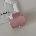 Close-up of a glossy pastel pink rectangular hair claw clip on a white minimal surface - Pink