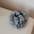 Detail of matte pleated texture on a foggy blue fabric scrunchie for hair styling - Green