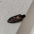 Detailaufnahme einer Vintage-Haarklammer mit Leopardenmuster auf grauem Stoffhintergrund - Nahtlose Clip / Acetat Schildpatt Leopard