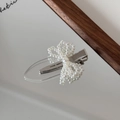 Eleganter Haarclip mit Perlen-Schleife und silberner Entenschnabel-Basis auf einem Spiegel - Perle Schleife Stil / Perlweiß