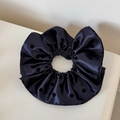Détail macro du chouchou en satin bleu marine avec d'élégants pois noirs en tissu - Bleu Marine