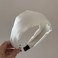 Primer plano de una diadema de satén blanco acolchada con diseño retro y textura sedosa - Blanco