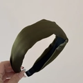 Detalle de la diadema acolchada de satén verde oliva con textura de tela premium - Verde