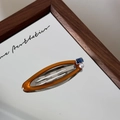 Primer plano detallado de la pinza de acetato ámbar con piedra azul cuadrada y perla - Clip Ovalado Caramelo-Cristal Azul