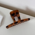 Vista dettagliata della trama tartarugata liscia su un fermaglio per capelli di alta qualità - Leopardo Caffè Dritto Corto