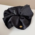 Detalle de coletero de satén negro con etiquetas bordadas y dije metálico dorado - Coletero Negro Etiqueta Dorada