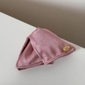 Detalle de coletero de satén rosa claro con placa metálica dorada y textura de seda - Pinza para el Pelo Rosa Etiqueta Dorada