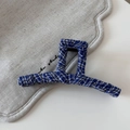 Close-up of blue and white checkered striped denim fabric hair claw clip on beige linen - Blue White Plaid Fabric Wrapped Claw