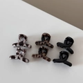 Detail view of small leopard print hair claws in resin material for styling short hair - Leopard X-Shaped