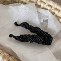 Detailed close-up of retro polka dot fabric texture on a black banana hair clip - Black Polka Dot
