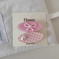 Détail de barrettes à fleurs roses avec perles et nœuds sur carte de présentation - Pince Ovale Rose Nœud