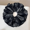 Detalle de un coletero plisado negro con patrones de conchas y etiqueta de marca - Doble Capa Huella Negro