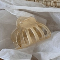 Grande molletta per capelli in resina traslucida champagne su un cesto di vimini - Beige