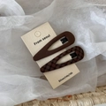 Detail view of brown fabric-covered snap hair clips with plaid and solid patterns - Teardrop / Coffee Plaid