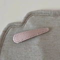 Detailansicht der rosa Satin-Haarklammer mit feinen Nähten auf Leinenuntergrund - Hellrosa Stoff Tränenclip