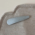 Nahaufnahme einer blauen Denim-Haarklammer in Tropfenform mit feinen Nähten auf Leinen - Blau Stoff Tränenclip