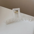 Detail view of a white marble texture hair claw clip with a strong gold metal spring - Jelly Transparent White