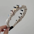 Gros plan détaillé d'un serre-tête en tricot beige avec des boutons colorés et un nœud - Serre-tête à Dents Nœud Bouton / Abricot