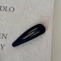 Macro shot of a black fabric-covered teardrop hair clip on a beige textured background - Hollow Water Drop-Navy Blue
