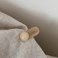 Macro view of handmade beige acrylic hair clip with France Handmade engraving on fabric - Beige