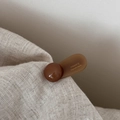 Detail of handmade brown acrylic hair clip showing the France Handmade text on linen - Light Coffee