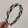 Vue détaillée du serre-tête à carreaux bleu et marron avec petit écusson décoratif - Serre-tête Basique / Carreaux Café