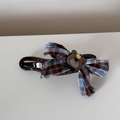 Dettaglio di un fermaglio per capelli marrone con fiocco a quadri blu e decoro a orsetto - Molletta a Becco d'Anatra / Quadri Blu