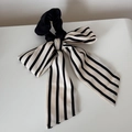 Détail d'un long chouchou à rayures noires et blanches avec un design de ruban doux - Ruban de Nœud Blanc à Rayures