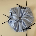 Detail van blauw gestreepte scrunchie met zwarte strikjes op een beige ondergrond - Blauw Gestreept Zwarte Strik - Grote Scrunchie