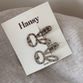 Detail of two cute bunny ear hair clips with polka dots and plaid patterns on card - Beige
