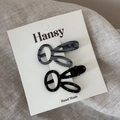 Close-up of two rabbit-shaped hair clips with polka dots and stripes on a display card - Dark Grey