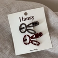Detail of red polka dot and brown plaid bunny hair clips on natural linen fabric - Reddish Brown