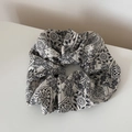 Macro-opname van witte oversized scrunchie met klassieke zwarte paisley bloemenprint - Literair Kunst Scrunchie - Wit