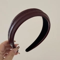Detail shot of the deep burgundy faux leather headband featuring a unique pleated texture - Red