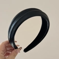 Close-up of black PU leather headband texture with soft padding and premium glossy finish - Black