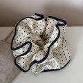 Détail d'un chouchou en satin à pois avec bordure en jean et texture douce et soyeuse - Bordure Denim à Pois / Blanc Cassé