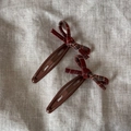 Detailed view of red plaid fabric bow hair clips with brown metal BB clip base - Red Plaid Bow Snap Clips Pair