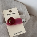 Close-up of sweet red cherry acetate hair clip on a display card with silver metal base - Cranberry