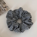 Detailopname van de zwart-wit geruite stoffen scrunchie met zachte geplooide textuur - Groot / Zwart-wit geruit