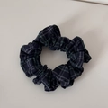 Detail view of small blue and green plaid scrunchie with soft pleated fabric texture - Navy Plaid
