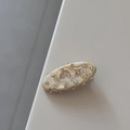 Barrette ovale en résine marbrée crème avec des petits strass blancs en gros plan - Marbre Blanc Crème