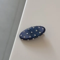 Gros plan d'une pince à cheveux ovale bleu marine ornée de strass étincelants - Bleu Foncé Brillant