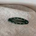 Close-up of oval dark green hair clip with white polka dots on linen texture background - Polka Dot Oval-Green