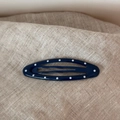 Close-up of a dark blue oval hair clip with white polka dots on linen fabric background - Polka Dot Oval-Blue