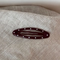 Close-up of deep red polka dot snap hair clips on a textured beige fabric background - Polka Dot Oval-Dark Red
