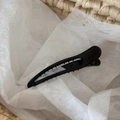 Détail d'une pince à cheveux noire brillante avec dents dentelées pour une prise sûre - Noir
