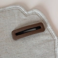 Vue macro de la pince à cheveux rectangulaire en tissu marron avec texture fine en lin - Café Rectangle