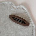 Gros plan d'une barrette BB en tissu marron tressé avec texture sur fond de lin doux - Café Ovale Creux