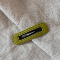 Detail of green velvet hair clip featuring stitching texture and black metal clasp - Rectangle / Yellow & Green