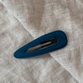 Close-up of a velvet teardrop snap clip with handcrafted stitching on linen fabric - Teardrop / Blue